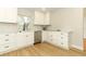 Well-lit kitchen with updated white cabinets, stainless steel appliances, and wood flooring at 656 Lake Charm Dr, Oviedo, FL 32765