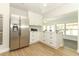 Modern kitchen with stainless steel refrigerator, white cabinetry, and marble countertops at 656 Lake Charm Dr, Oviedo, FL 32765