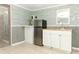 Kitchenette featuring stainless fridge, sink, white cabinets and a charming nautical-themed wallpaper at 656 Lake Charm Dr, Oviedo, FL 32765