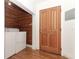 Bright laundry room with wood accent wall, washer, dryer, and decorative door at 656 Lake Charm Dr, Oviedo, FL 32765
