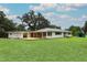 Well-manicured lawn and large backyard with a wooden deck overlooking the peaceful surroundings at 656 Lake Charm Dr, Oviedo, FL 32765