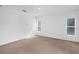 Bright, neutral bedroom with carpet, large windows, and minimalist decor at 672 Reindeer Dr, Kissimmee, FL 34759