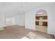 Neutral living room that opens to the kitchen with archway and chandelier at 672 Reindeer Dr, Kissimmee, FL 34759