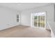 Sunlit living room with large windows, neutral carpet and patio access, offering a seamless indoor-outdoor experience at 672 Reindeer Dr, Kissimmee, FL 34759
