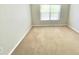 This bright bedroom offers a window with bright natural light and neutral carpeting at 7054 Cadiz Blvd, Orlando, FL 32819