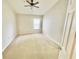 A light-filled room features neutral carpet, ceiling fan, and a bright window with natural light at 7054 Cadiz Blvd, Orlando, FL 32819