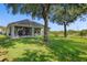 Lush backyard showcasing green lawn, mature trees, and a glimpse of the home's screened lanai at 7201 Halton Ct, Windermere, FL 34786