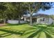 Green backyard featuring well-maintained lawn, mature trees, a white fence, and a screened porch at 7201 Halton Ct, Windermere, FL 34786