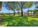 Lush backyard with a green lawn, mature trees, and a view of neighborhood amenities at 7201 Halton Ct, Windermere, FL 34786
