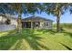 Well-maintained backyard featuring a lush green lawn, mature trees, and a view of the home's exterior at 7201 Halton Ct, Windermere, FL 34786