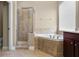 Bathroom featuring a glass-enclosed shower, corner tub, and tile surround at 7201 Halton Ct, Windermere, FL 34786
