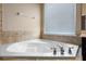 Corner bathtub with tile surround, chrome fixtures and natural light at 7201 Halton Ct, Windermere, FL 34786