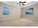 Spacious bedroom with neutral carpet, ceiling fan, and natural light from two large windows at 7201 Halton Ct, Windermere, FL 34786