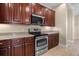 Close up of an updated kitchen showcasing modern appliances, dark cabinets, and stone countertops at 7201 Halton Ct, Windermere, FL 34786