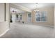 Spacious living room with neutral carpet, natural light from large windows, and elegant chandelier at 7201 Halton Ct, Windermere, FL 34786