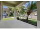 Covered porch with a view of the street, lush tropical landscaping, and a blue car parked nearby at 7201 Halton Ct, Windermere, FL 34786