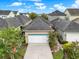 Aerial view of home showing a two-car garage, concrete driveway, manicured landscaping, and other houses at 8245 Laureate Blvd, Orlando, FL 32827
