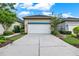 Exterior of home featuring a two-car garage with concrete driveway and manicured landscaping at 8245 Laureate Blvd, Orlando, FL 32827