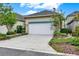 Exterior of home featuring a two-car garage with concrete driveway, lush grass and manicured landscaping at 8245 Laureate Blvd, Orlando, FL 32827