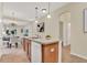 Open-concept kitchen island offers a breakfast bar, stainless steel sink, and seamlessly connects to the dining area at 8245 Laureate Blvd, Orlando, FL 32827