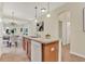 Open-concept kitchen island offers a breakfast bar, stainless steel sink, and seamlessly connects to the dining area at 8245 Laureate Blvd, Orlando, FL 32827