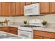 Modern kitchen features white appliances, wood cabinets, and sleek countertops, perfect for culinary enthusiasts at 8245 Laureate Blvd, Orlando, FL 32827