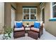 Inviting outdoor patio features comfortable wicker chairs, foot rests, a table and lush plants at 8245 Laureate Blvd, Orlando, FL 32827