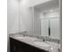 Primary bathroom showcasing double sinks, granite countertop, dark cabinets and walk-in shower at 856 Teton St, Haines City, FL 33844