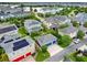 Aerial view of neighborhood with solar panels, green spaces, and a nearby lake at 8692 Tavistock Lakes Blvd, Orlando, FL 32827