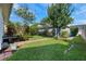Manicured back yard featuring lush landscaping and a storage shed at 8692 Tavistock Lakes Blvd, Orlando, FL 32827