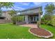 Spacious backyard showcasing a covered patio with brick flooring and lush landscaping at 8692 Tavistock Lakes Blvd, Orlando, FL 32827