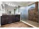 Bathroom with double vanity, dark wood cabinets, granite countertops, and tiled walk-in shower at 8692 Tavistock Lakes Blvd, Orlando, FL 32827