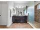 Bathroom with double vanity, dark wood cabinets, granite countertops, and tiled walk-in shower at 8692 Tavistock Lakes Blvd, Orlando, FL 32827