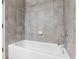 Updated white bathtub with chrome faucet and gray shower tile at 8692 Tavistock Lakes Blvd, Orlando, FL 32827