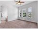 Light bedroom with a ceiling fan, carpet, and a wall of three windows looking to the street at 8692 Tavistock Lakes Blvd, Orlando, FL 32827