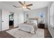 Light, bright bedroom with ceiling fan, decorative rug, and private en suite bathroom at 8692 Tavistock Lakes Blvd, Orlando, FL 32827