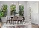 Bright dining room with hardwood floors, large windows, modern decor, and table setting at 8692 Tavistock Lakes Blvd, Orlando, FL 32827