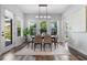 Elegant dining room bathed in natural light featuring modern table set, neutral decor, and view to landscaped yard at 8692 Tavistock Lakes Blvd, Orlando, FL 32827