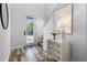 Bright entryway featuring wood-look tile flooring, white walls, and a stylish console table at 8692 Tavistock Lakes Blvd, Orlando, FL 32827
