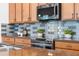 Modern kitchen with granite countertops, stainless steel appliances, and decorative backsplash at 8692 Tavistock Lakes Blvd, Orlando, FL 32827