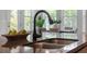 The kitchen island with a sink and faucet, complemented by views of the dining area and exterior at 8692 Tavistock Lakes Blvd, Orlando, FL 32827