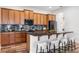 Gourmet kitchen boasts wooden cabinetry, stylish backsplash, granite countertops, and a convenient breakfast bar with seating at 8692 Tavistock Lakes Blvd, Orlando, FL 32827