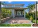 View of a brick patio with a ceiling fan overlooking the landscaped backyard and garden at 8692 Tavistock Lakes Blvd, Orlando, FL 32827