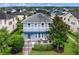 Aerial view of the home's rear exterior, with a patio and seating surrounded by lush landscaping at 8692 Tavistock Lakes Blvd, Orlando, FL 32827