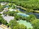 Aerial view of community amenities featuring a pool, tennis courts, a lake and more at 9330 Shadow Pinar Ct, Orlando, FL 32825