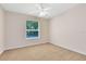 This bedroom features neutral paint, carpet flooring, a ceiling fan, and a window at 9330 Shadow Pinar Ct, Orlando, FL 32825