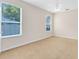 This bedroom features neutral paint, carpet flooring, a ceiling fan, and dual windows at 9330 Shadow Pinar Ct, Orlando, FL 32825