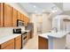 This kitchen features wood cabinets, stainless steel appliances, and a white countertop breakfast bar at 9330 Shadow Pinar Ct, Orlando, FL 32825