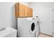 Bright laundry room with modern washer and dryer, storage cabinets, and utility sink at 9330 Shadow Pinar Ct, Orlando, FL 32825