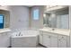 Bright bathroom featuring a soaking tub, a glass-enclosed shower, and white cabinets and countertop at 9917 Summerlake Groves St, Winter Garden, FL 34787